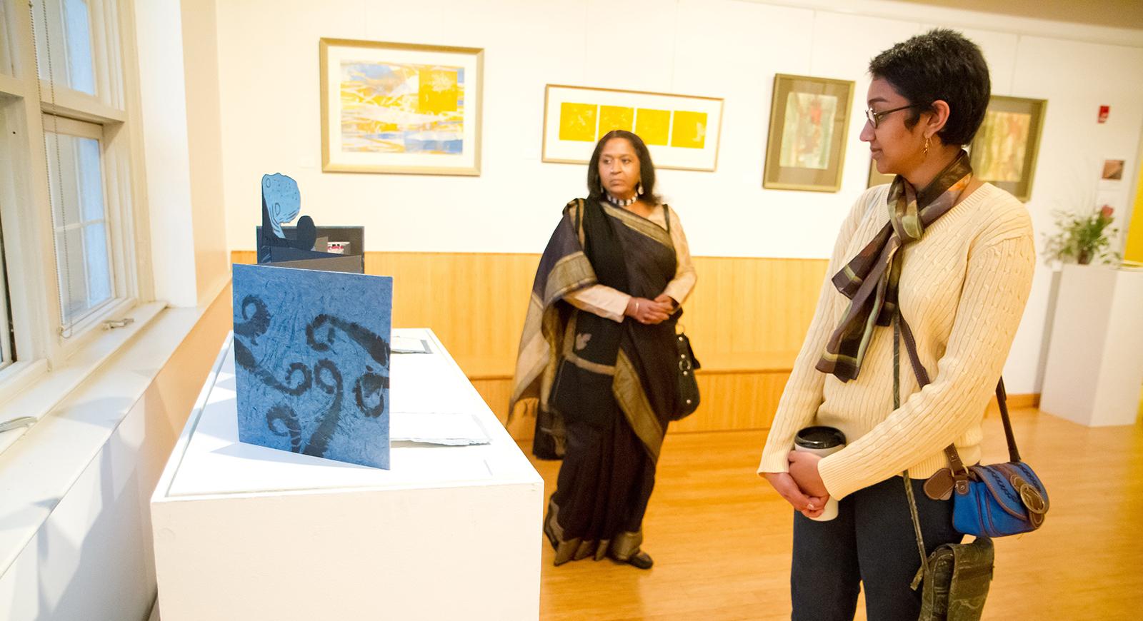 两名妇女在波胆网站的媒体艺术画廊里观看装置. 