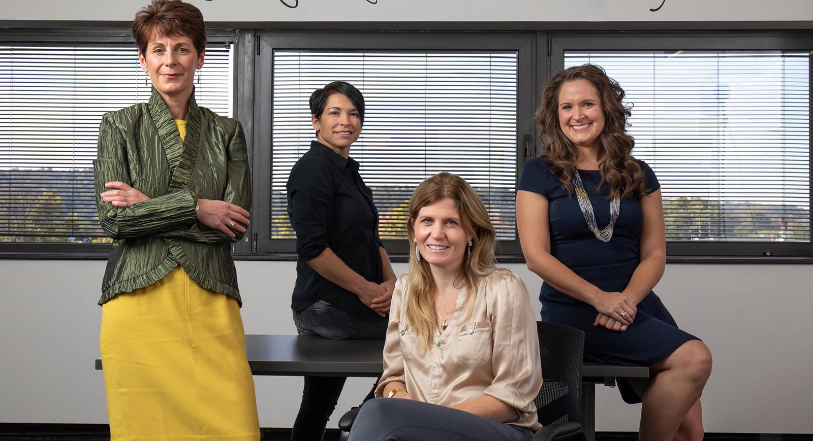 图为四名女性在查塔姆足球波胆平台的办公室里合影.